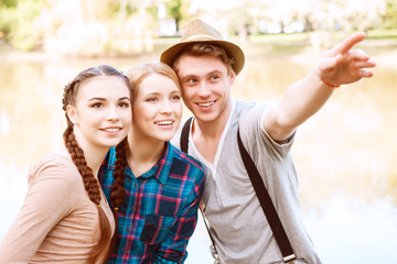 Naklejka premium Handsome man with two girls pointing aside