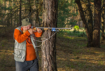 Senior hunter aim rifle in forest