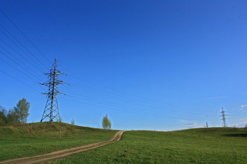 power line in a meadow and dirt road