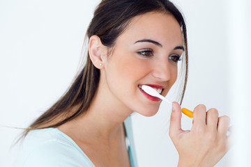 Pretty young woman brushing her teeth.