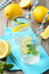 Fresh lemonade with lemon on grey wooden background