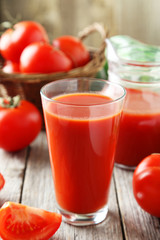 Fresh red tomatos in basket and juice in glass 