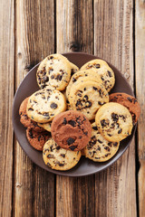 Chocolate chip cookies on plate on brown wooden background