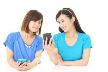 スマートフォンを持つ二人の女性