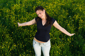 Naklejka na ściany i meble Young woman enjoying life at field of flowers .