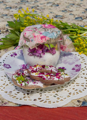 Candied lilac flowers in a glass jar and cookies