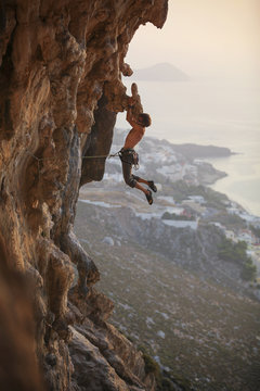 Male rock climber struggling on challenging route, Kalymnos Island, Greece 