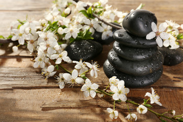 Spa stones with spring flowers on wooden background