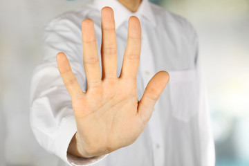Fototapeta premium Male hand showing stop gesture, closeup