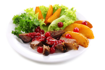 Beef with cranberry sauce, roasted potato slices on plate, isolated on white