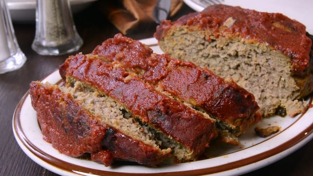 Taking a slice of meatloaf to the plate
