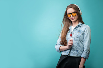 Cheerful Hipster woman with headphones and candy
