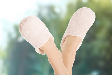 Female legs in white slippers.
