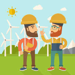 Two workers talking infront of windmills.