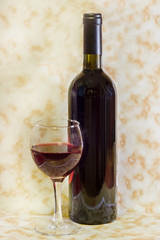 Glass with red wine and bottle