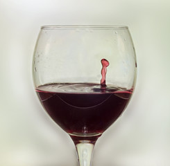 Glass with red wine and drop