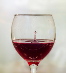 Glass with red wine and drop