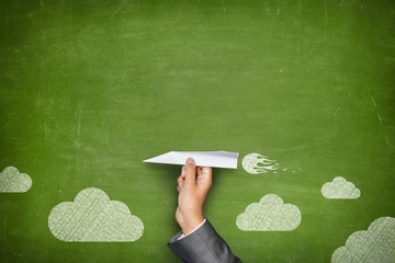 Black blank blackboard with hand holding paper plane
