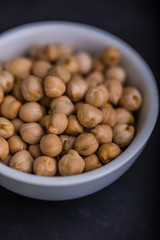 Chickpeas in a white bowl on a black background