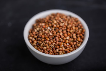 Sorghum in a white bowl on a black background