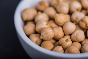 Chickpeas in a white bowl on a black background