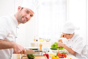 Young attractive professional chef cooking in his kitchen
