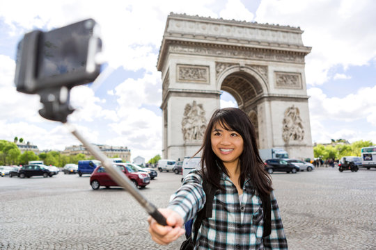 Young attractive asian tourist in Paris taking selfie