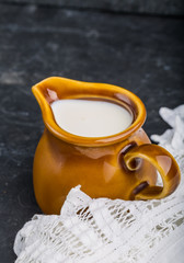 Jug with milk on a black background