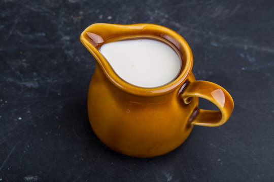 Jug with milk on a black background