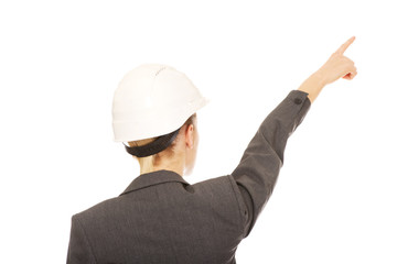 Businesswoman in hard hat pointing up.