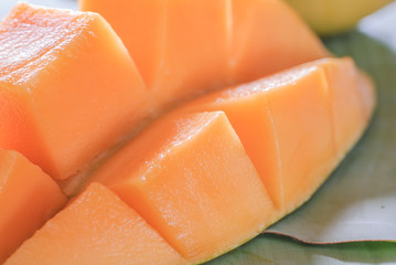 Ripe mango with slices on banana leaves