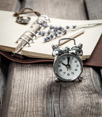 Vintage grunge still life with watch, and old book and pencil.