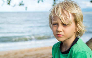 Portrait of a young worried boy at the beach