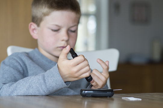 Young boy measure glucose level