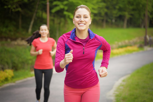 Smiling friends running outdoors.