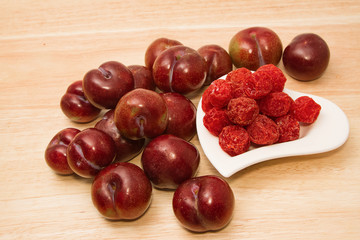 Dried plums and fresh plums on the wooden table