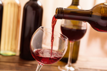 Red wine pouring into glass, close-up.