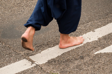 homme marchant pieds nus sur une route