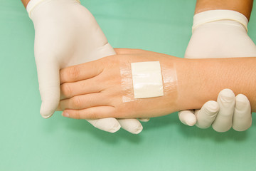 doctor applying plaster on pateint's hand