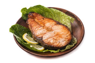 Baked steak trout with lemon and salad on white background