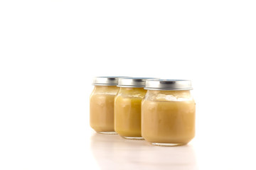 Three jars with fruit puree each other in an oblique row 