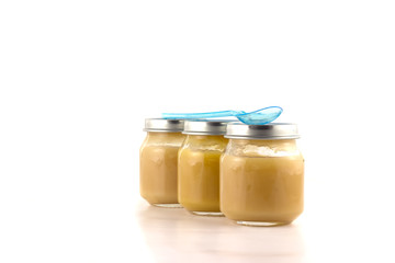 Three jars of fruit puree with a plastic spoon