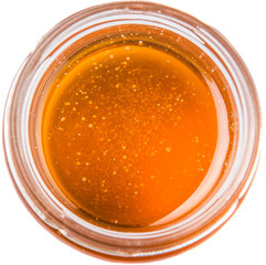 Honey in a mason jar over white background