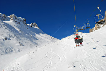 Fototapeta na wymiar Skiers and snowboarders on a ski lift
