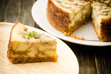 Banana caramel cheesecake on wooden plate