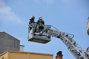 bomberos trabajando sobre una grua
