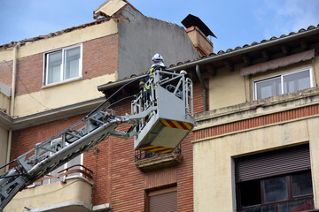 bomberos trabajando sobre una grua
