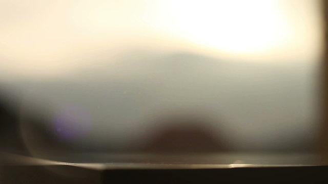 Shot of alcoholic beverage, residuary drops flowing down with sun flares