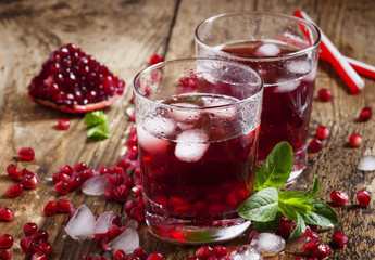Fresh red juice cocktail with pomegranate seeds, mint and ice, s