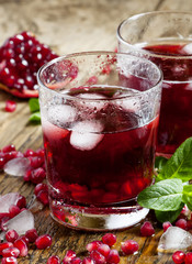 Fresh red juice cocktail with pomegranate seeds, mint and ice, s